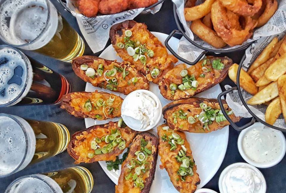 Overhead of beer, potato skins and other appetizers