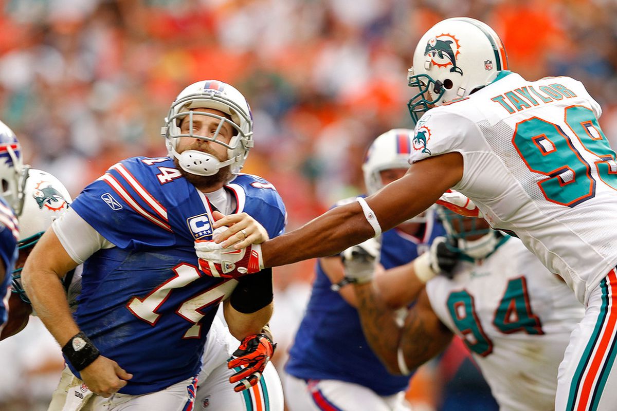 MIAMI GARDENS, FL - NOVEMBER 20:  Ryan Fitzpatrick #14 of the Buffalo Bills is grabbed by Jason Taylor #99 of the Miami Dolphins during a game at Sun Life Stadium on November 20, 2011 in Miami Gardens, Florida.  (Photo by Mike Ehrmann/Getty Images)