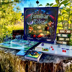 The components in Familiar Tales include a miniature model and a caddy for storing resource tokens.
