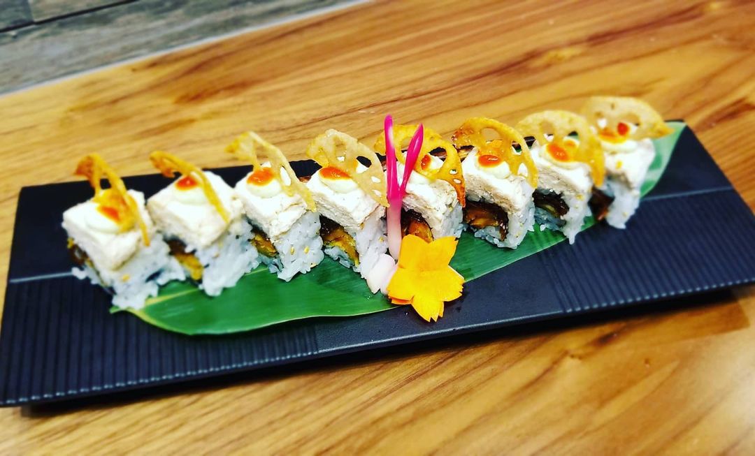 A black plate with vegan sushi