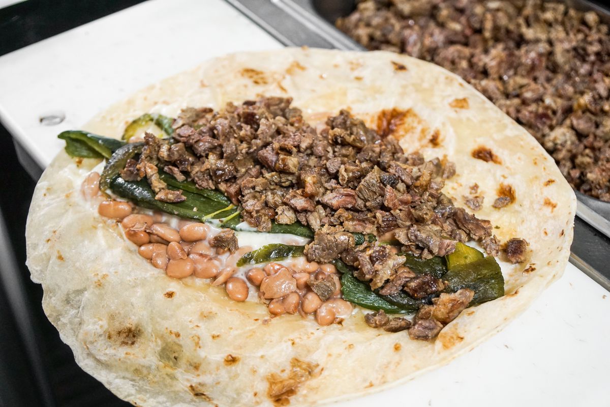 Beef, chiles, and beans inside a flour tortilla.