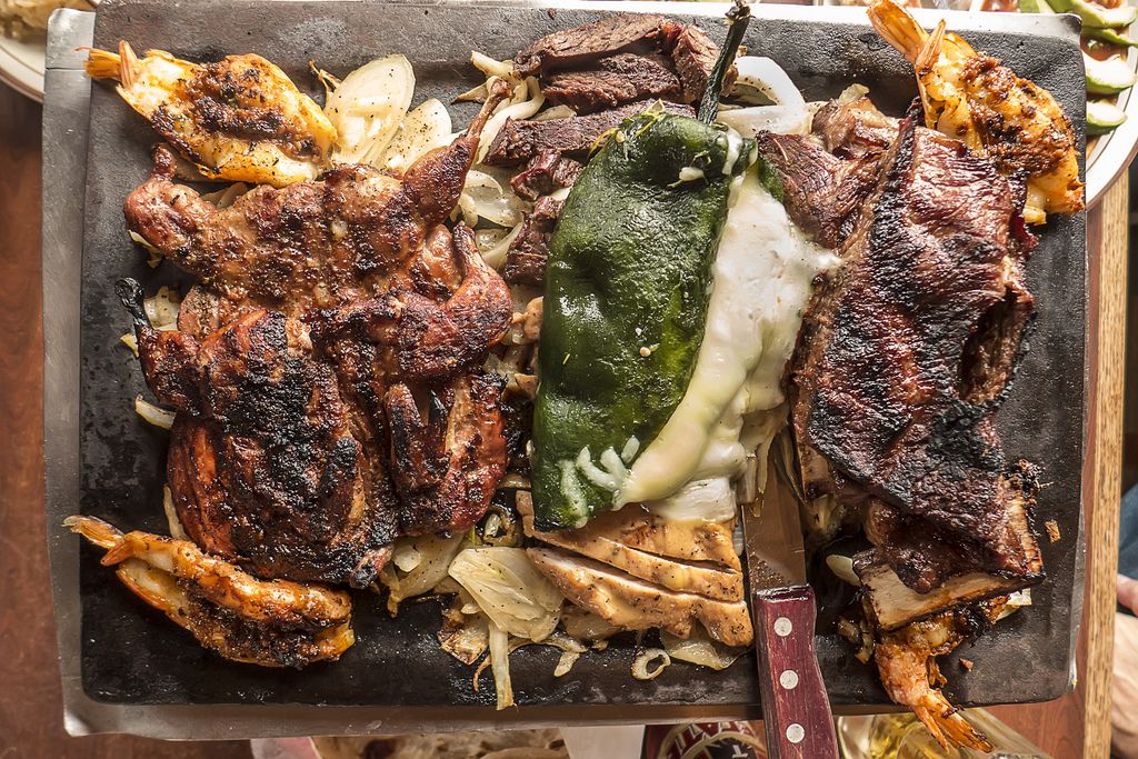 a platter of grilled meats and peppers.