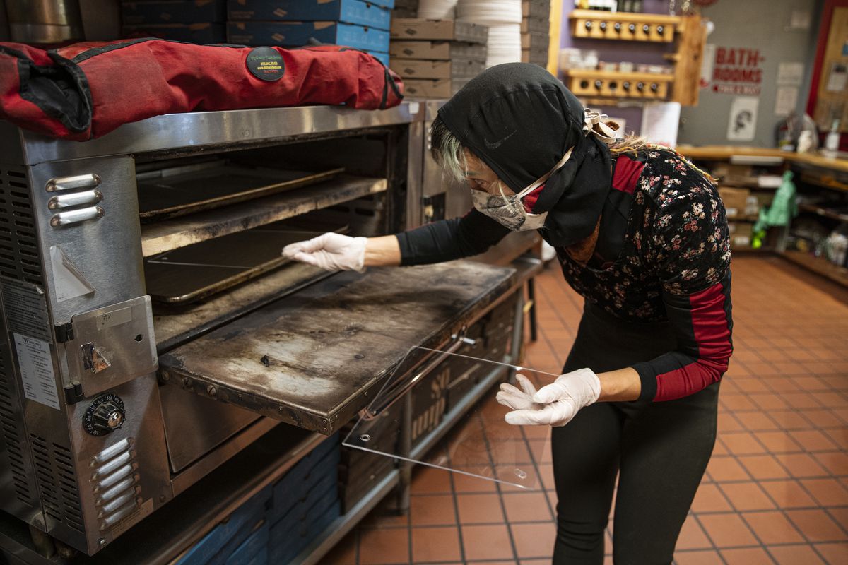 Tara Kline inserts clear acrylic into an oven for face shields that are being made for an order of fifty for a bus driver at Dimo’s Pizza at 1615 N Damen Ave. in Wicker Park, Thursday, Oct. 29, 2020. | Anthony Vazquez/Sun-Times
