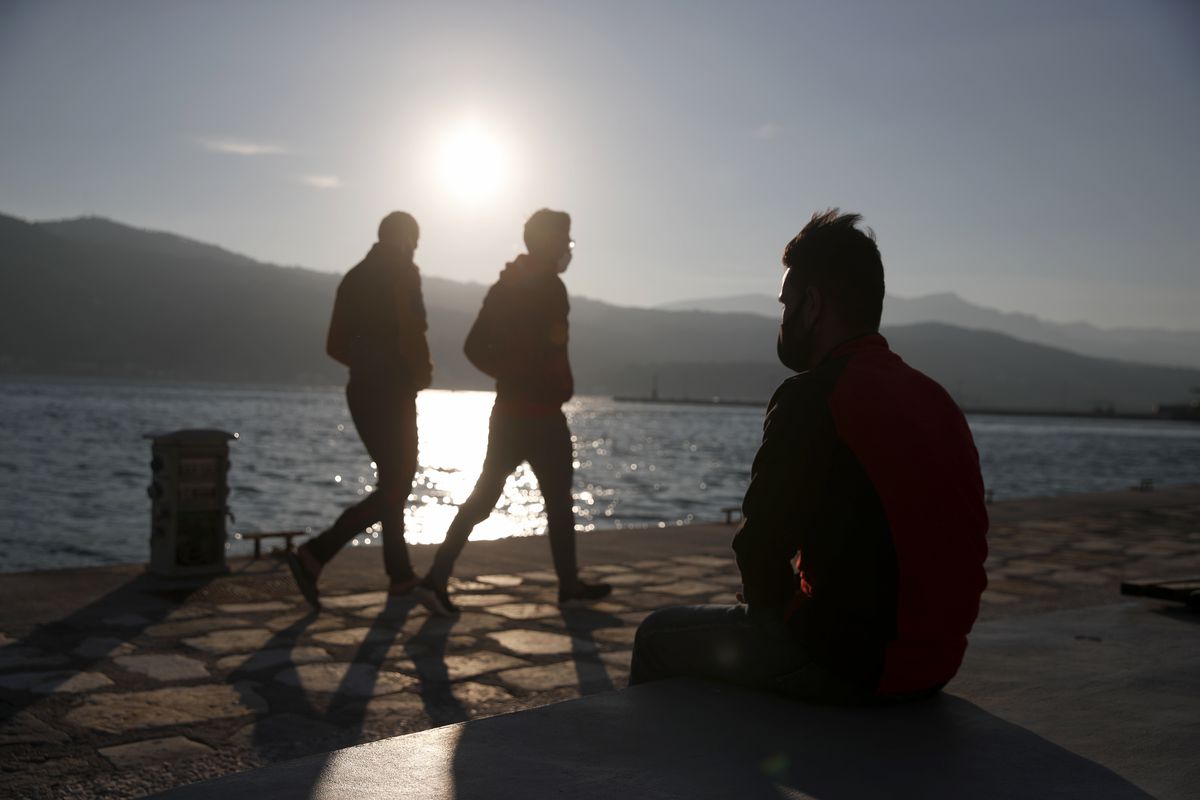 An Afghan father sits on a bench at the port of Vathy on the eastern Aegean island of Samos, Greece.