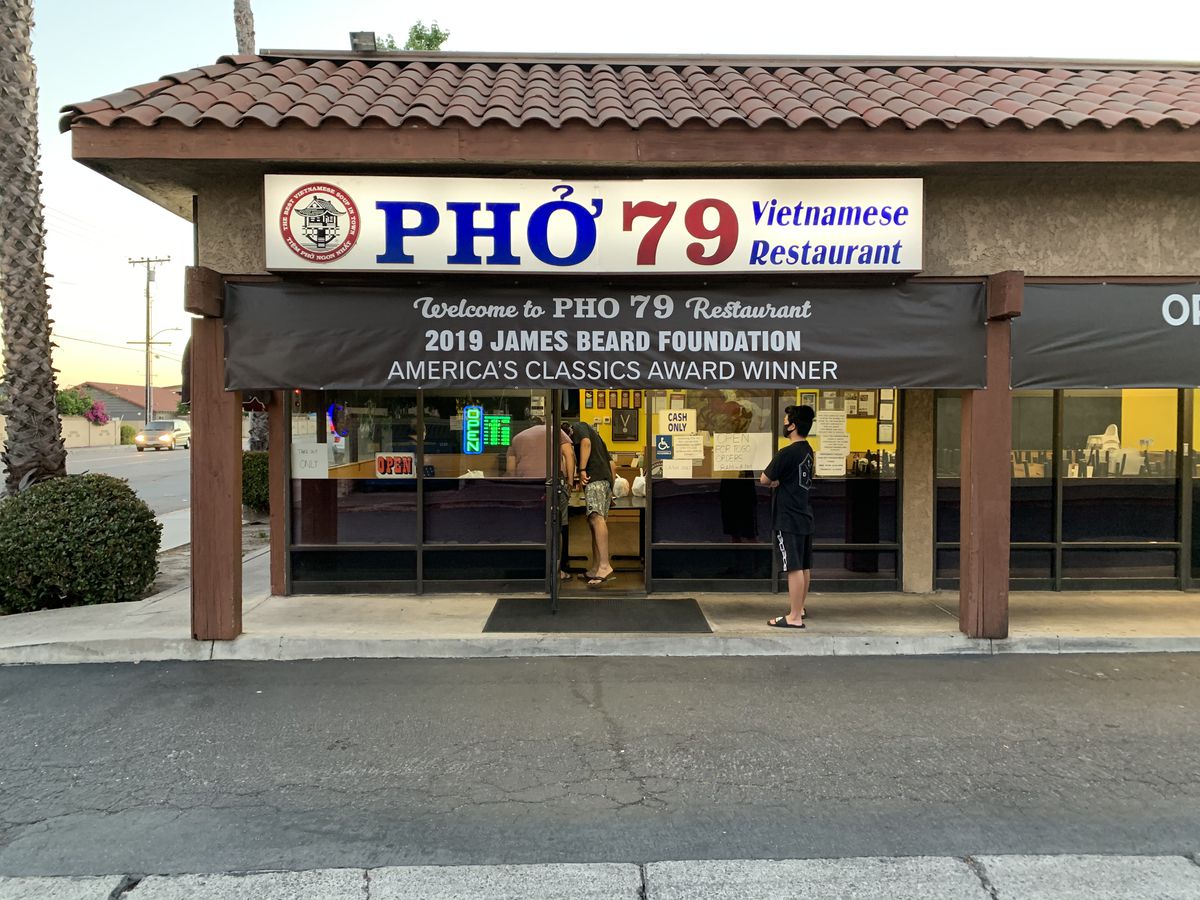 Customers wait to pick up takeout at Pho 79 in Garden Grove