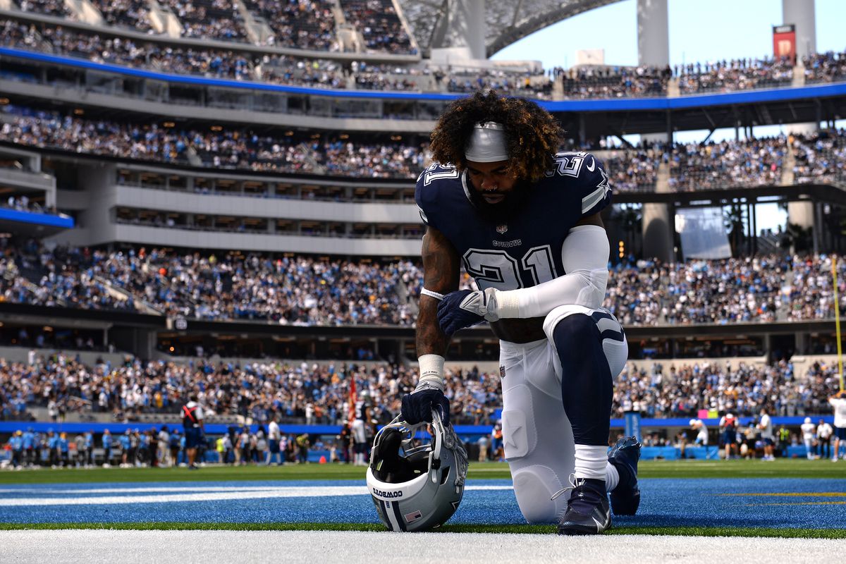 Dallas Cowboys running back Ezekiel Elliott (21) kneels in the end zone before the game against the Los Angeles Chargers at SoFi Stadium.