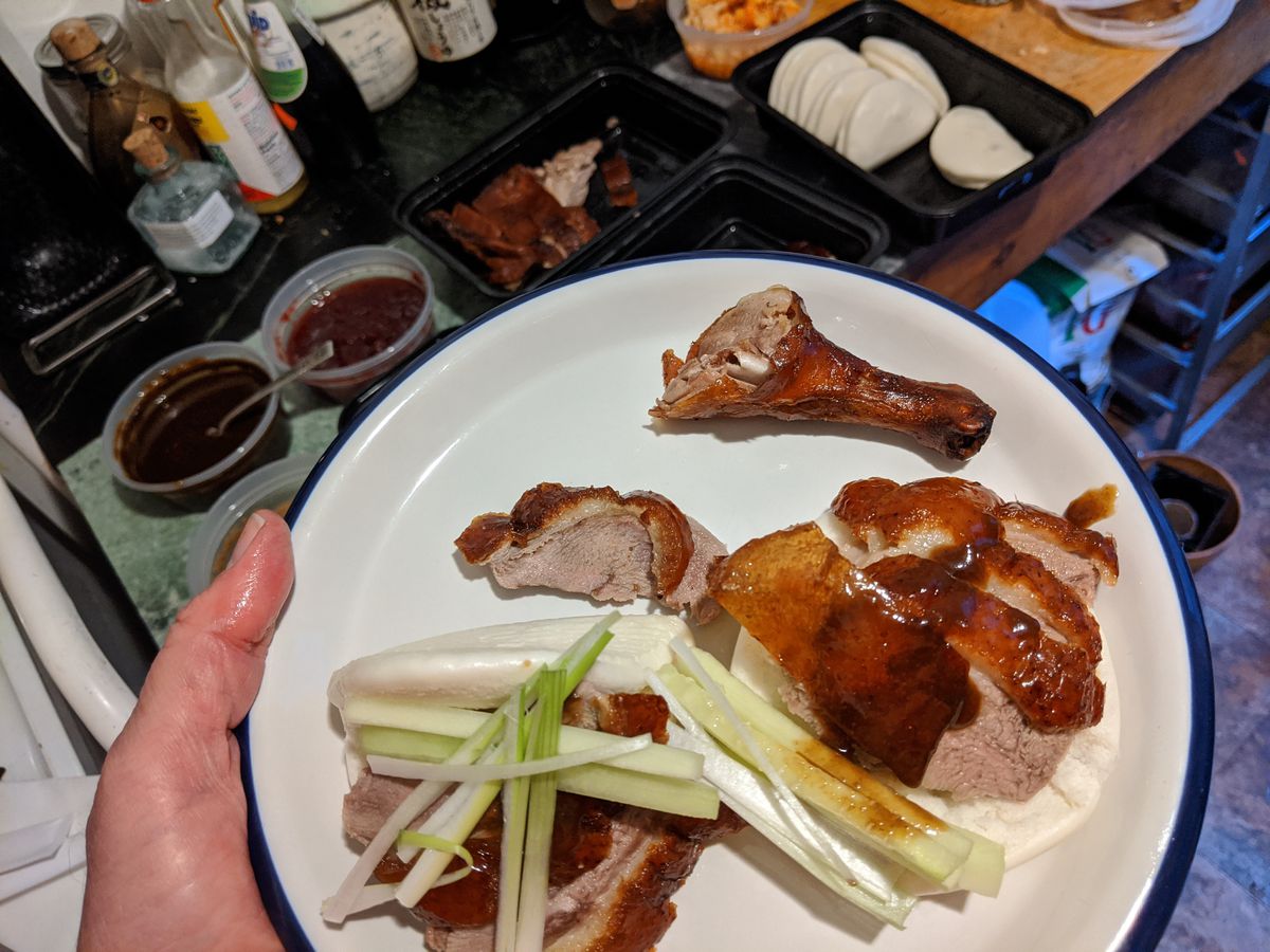 A plate of duck in bao and a leg by itself.