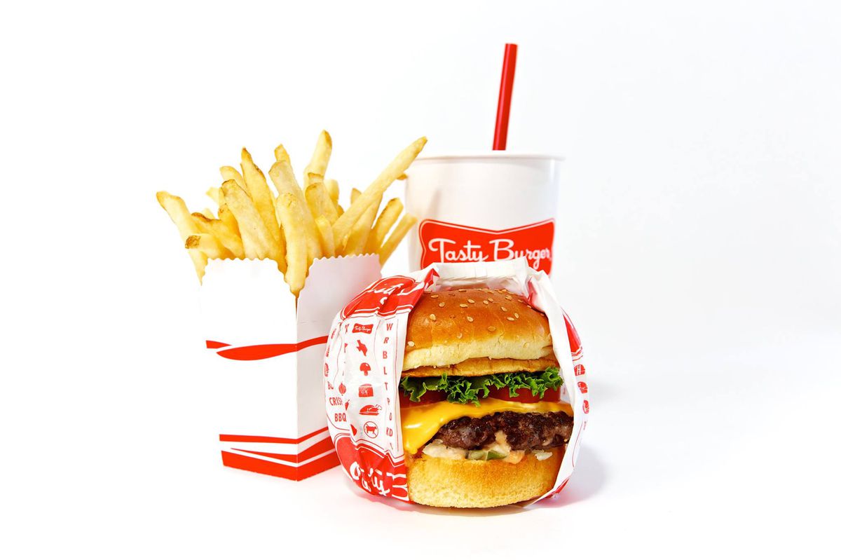 A fast-food burger, fries, and a soda in red and white packaging, isolated on a white background.