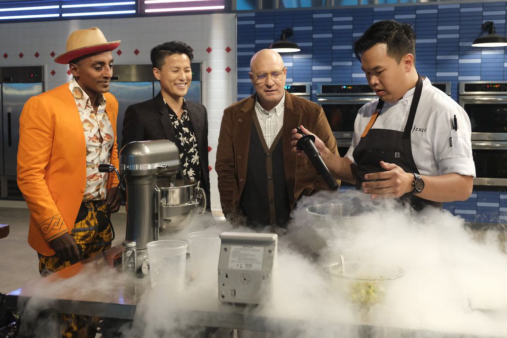 Marcus Samuelsson, Melissa King, Tom Colicchio, and Buddha Lo in the top chef kitchen as Lo presents a dish that emits a fog.