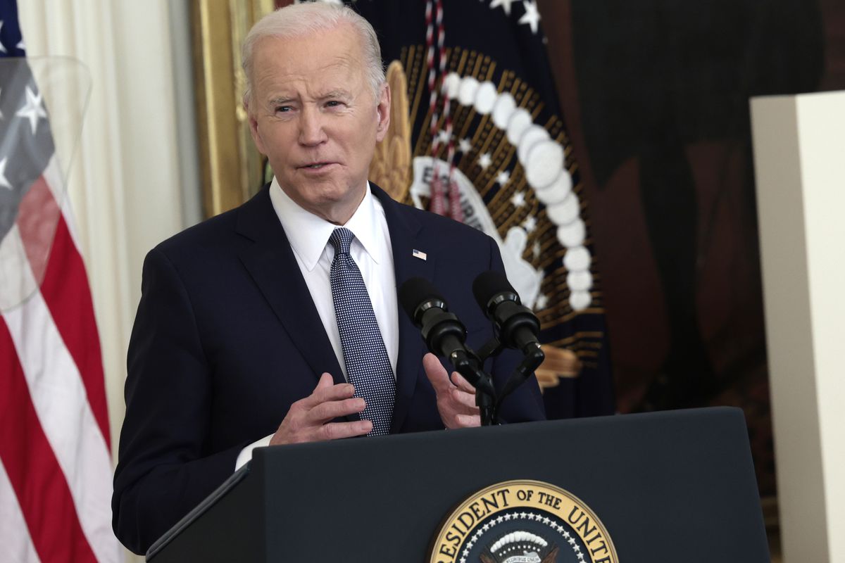 President Biden stands at a lectern wearing a suit. 