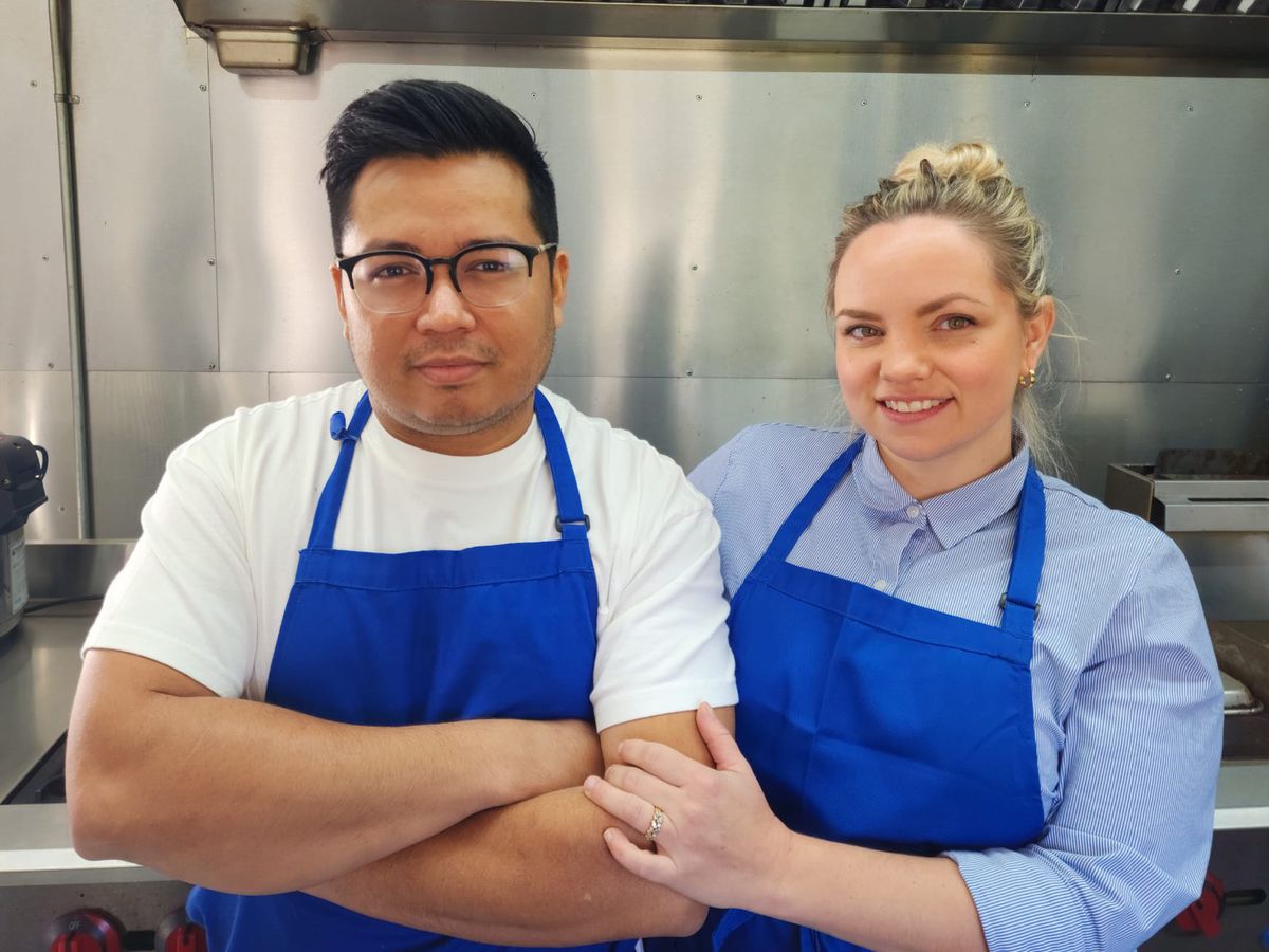 A man and woman in blue aprons.