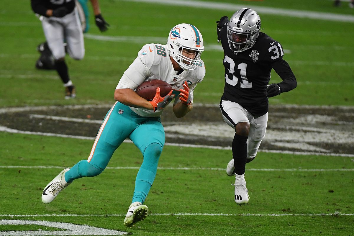 Mike Gesicki #88 of the Miami Dolphins is pursued by Isaiah Johnson #31 of the Las Vegas Raiders at Allegiant Stadium on December 26, 2020 in Las Vegas, Nevada.