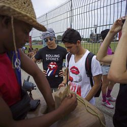 Fans buy ice-cream as they wait outside the venue where the Rolling Stones will play their concert in Havana, Cuba, Friday, March 25, 2016. The Stones are performing in a free concert in Havana Friday, becoming the most famous act to play Cuba since its 1959 revolution.