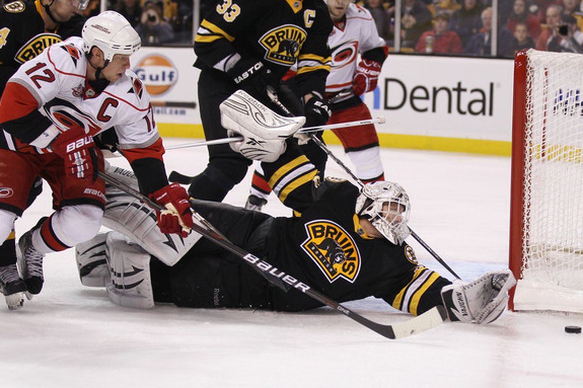BOSTON - NOVEMBER 26:  Tim Thomas #30 of the Boston Bruins stops a shot by Eric Staal #12 of the Carolina Hurricanes on November 26 2010 at the TD Garden in Boston Massachusetts.  (Photo by Elsa/Getty Images)