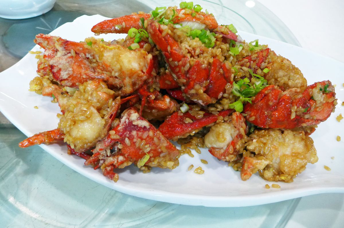 A heap of red shelled lobsters dotted with grains of sticky rice.