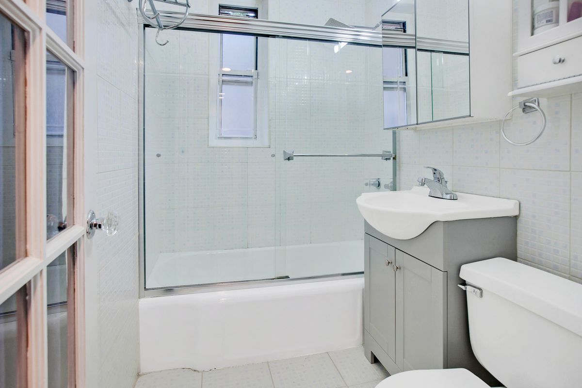 A bathroom with white tiles.