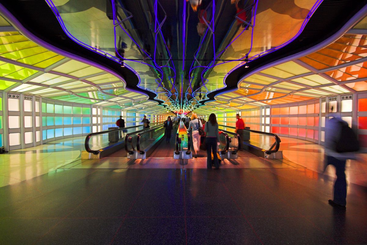 The interior of the Terminal 1 tunnel in the Chicago O’Hare airport. The walls are multicolored. 