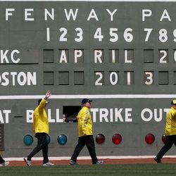 Boston Marathon volunteer workers walk onto the field before a baseball game between the Boston Red Sox and the Kansas City Royals in Boston, Saturday, April 20, 2013. 
