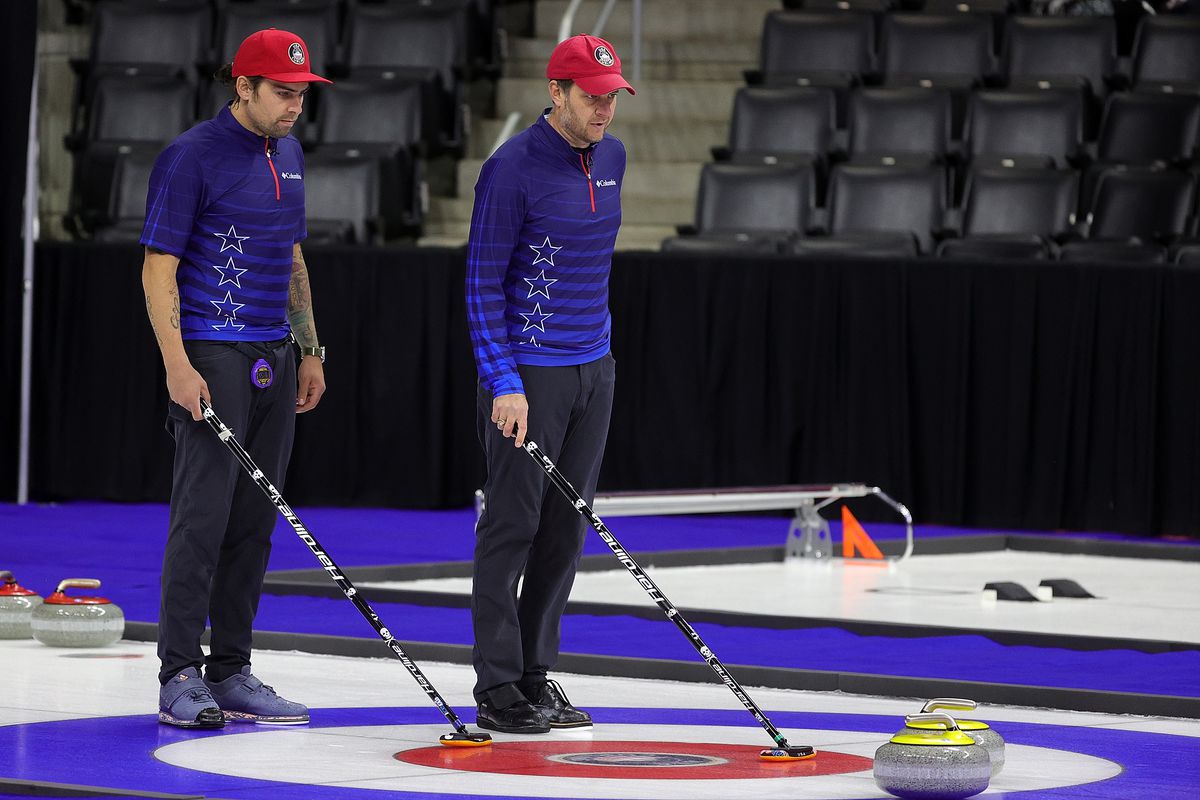 Chris Plys of the United States and John Shuster of the United States prepare to deliver a stone during Game 3 of the US Olympic Team Trials at Baxter Arena on November 21, 2021 in Omaha, Nebraska.
