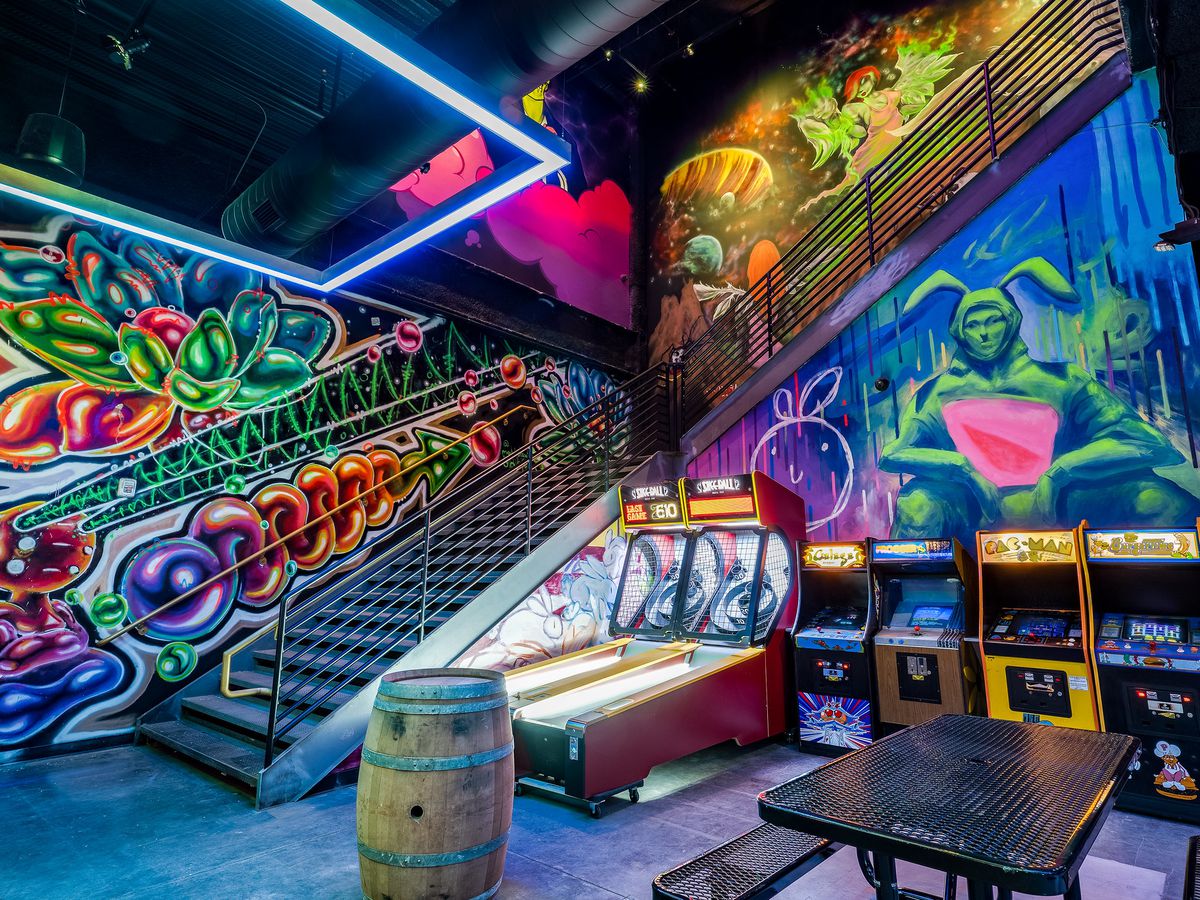 A bar with graffiti art and gaming machines.