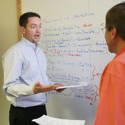 Nate Johns works with colleague Ferris Taylor at Arches Health in Salt Lake City Wednesday, June 26, 2013. The Department of Workforce Services uses a bridge program that helps small companies provide training so they can hire new employees.