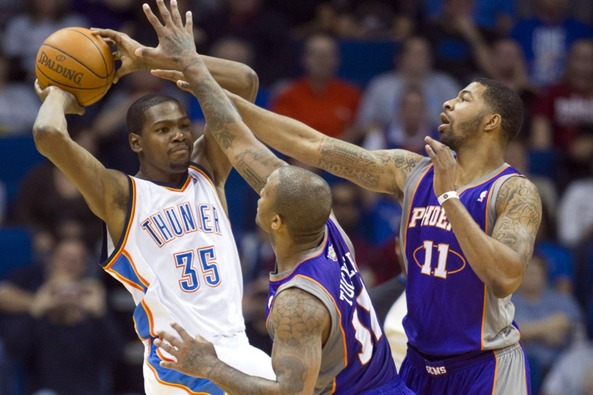 Tulsa, OK, USA; Oklahoma City Thunder forward Kevin Durant (35) looks to make a pass under pressure from Phoenix Suns forward P.J. Tucker (17) and forward Markieff Morris (11) during the first half of a game at the BOK Center. Thunder defeated the Su