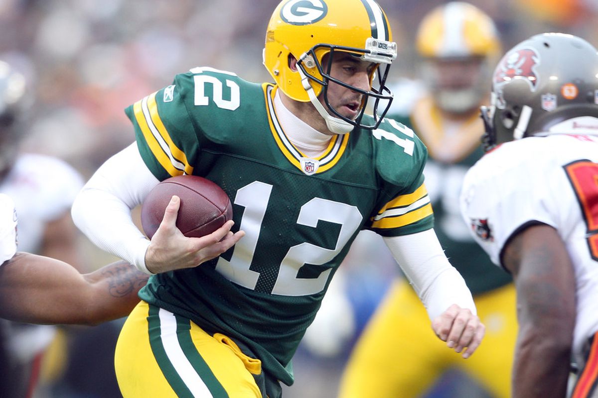 GREEN BAY, WI - NOVEMBER 20:  Aaron Rodgers #12 of the Green Bay Packers carriesn the ball in the first quarter against the Tampa Bay Buccaneers on November 20,2011 at Lambeau Field in Green Bay, Wisconsin.  (Photo by Elsa/Getty Images)
