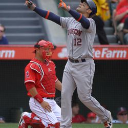 Houston Astros' Carlos Pena, right, gestures after hitting a solo home run as Los Angeles Angels catcher Hank Conger looks on during the fifth inning of their baseball game on Sunday, June 2, 2013, in Anaheim, Calif. 