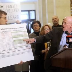 Neil Rickard, a child nutrition advocate, holds a poster featuring breakdown of a possible tax plan without a tax on food as Matthew Weinstein, state priorities partnership director for Voices of Utah Children, talks about the plan during a press conference at the Capitol in Salt Lake City on Wednesday, Nov. 20, 2019.