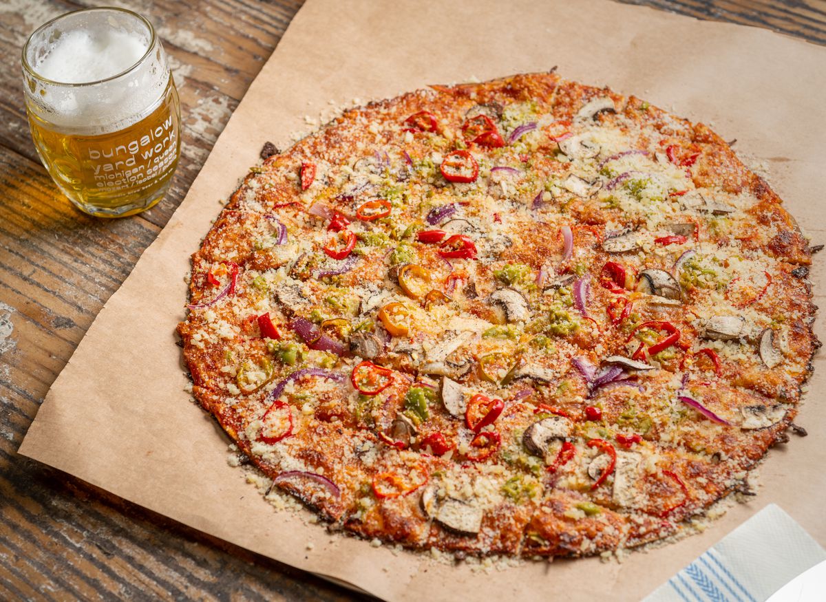A pizza with a mug of beer.