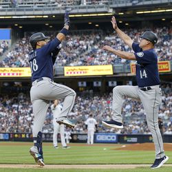 AUGUST 02: Eugenio Suarez #28 of the Seattle Mariners celebrates his first inning two run home run against the New York Yankees with third base coach Manny Acta #14 at Yankee Stadium on August 02, 2022 in New York City.