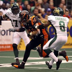 Utah Blaze's Chase Deadder runs with the ball as San Jose's Huey Whittaker (17) and Clevan Thomas try to tackle him during a football game between the Utah Blaze and the San Jose SaberCats at EnergySolutions Arena in Salt Lake City on Saturday, June 29, 2013.