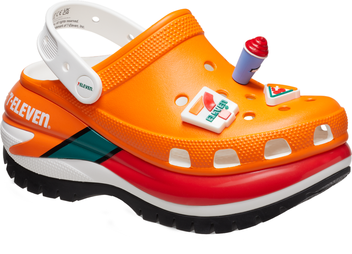 An orange Croc holds a Slurpee charm that sticks out from the mid-foot area.