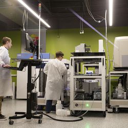 Automation scientist August Allen and technician Lawrie Allred work in the robotics lab at Recursion Pharmaceuticals in Salt Lake City on Wednesday, May 26, 2017.