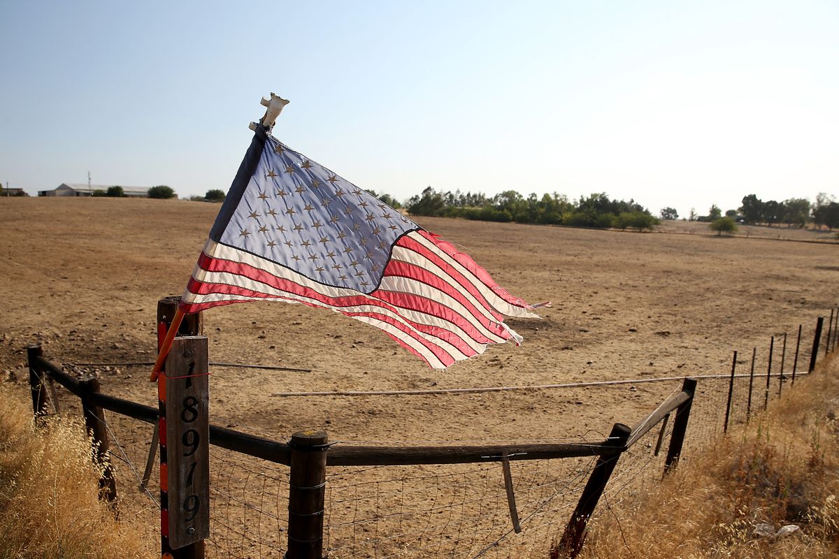 An American flag is posted on a fence in front of a dry unplanted field on August 8, 2014 in Lodi, California. (Photo by Justin Sullivan/Getty Images)