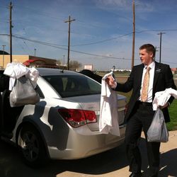 Elder Talon Shumway and his companion carry baptismal clothing into the church. Elder Shumway, a former Lone Peak High basketball player, is serving in the Texas McAllen Mission.