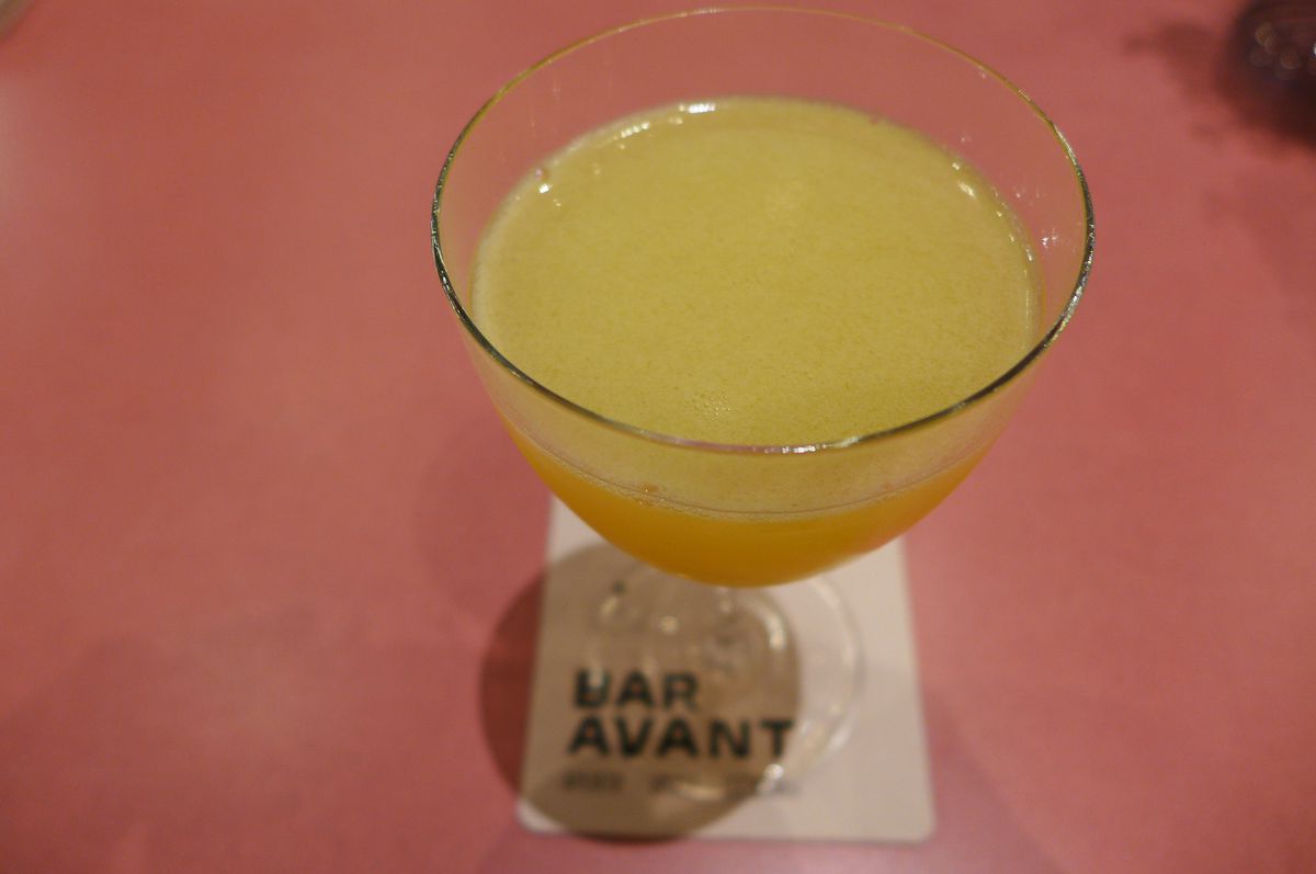 A bright yellow cocktail in a stem glass.