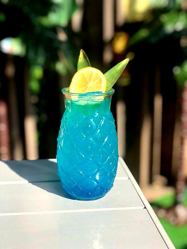 A blue cocktail sitting outside