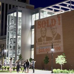 A sold sign featuring an image of the Koch brothers was projected on a wall of the Jon M. Huntsman School of Business at Utah State University in protest of a recent $25 million gift to the school.
