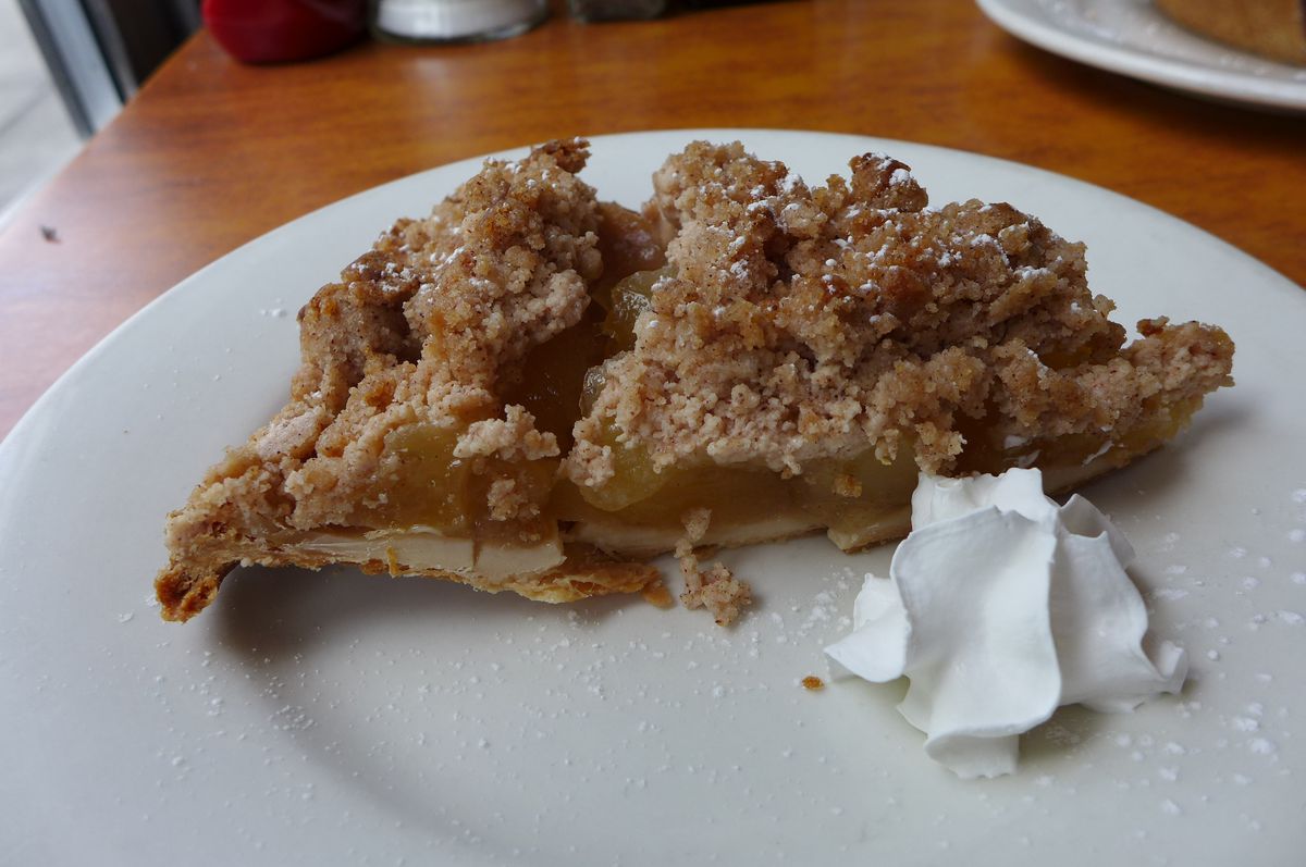 A very flat looking slice of pie with the crumb coating on top most prominent.
