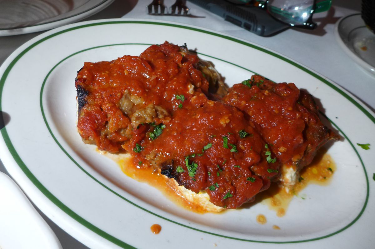 Two big humps of red sauce-cloaked eggplant has  ricotta cheese oozing out at the edges.