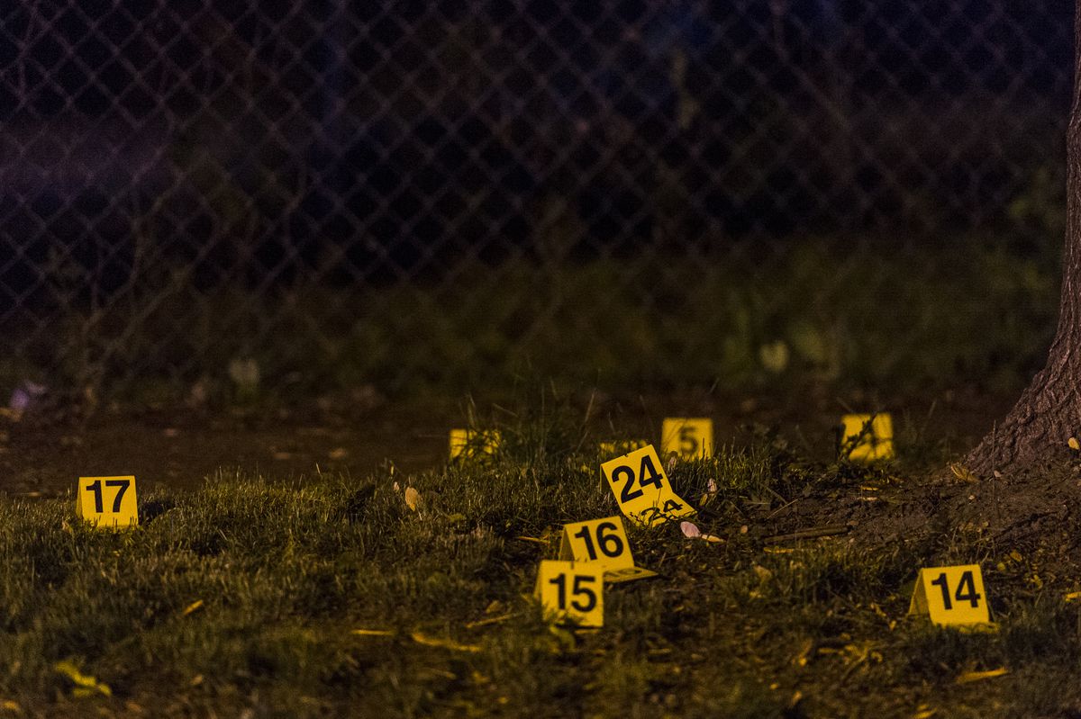 Dozens of evidence markers litter a sidewalk and the grass at a scene of a shooting Saturday morning in the 3500 block of North Albany Avenue. | Tyler LaRiviere/Sun-Times