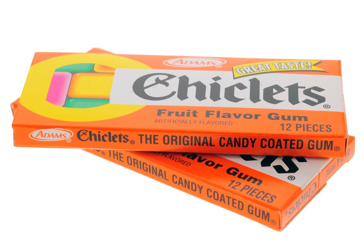 A stack of two bright orange retro packets of Chiclets gum, decorated with candy-color graphics.