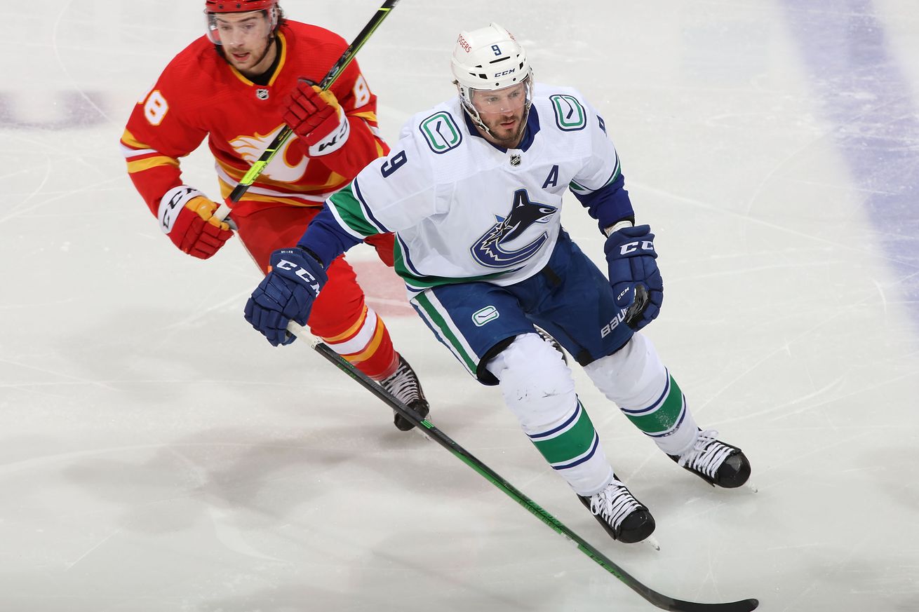 J.T. Miller #9 of the Vancouver Canucks skates against Andrew Mangiapane #88 of the Calgary Flames at Scotiabank Saddledome on May 19, 2021 in Calgary, Alberta, Canada.