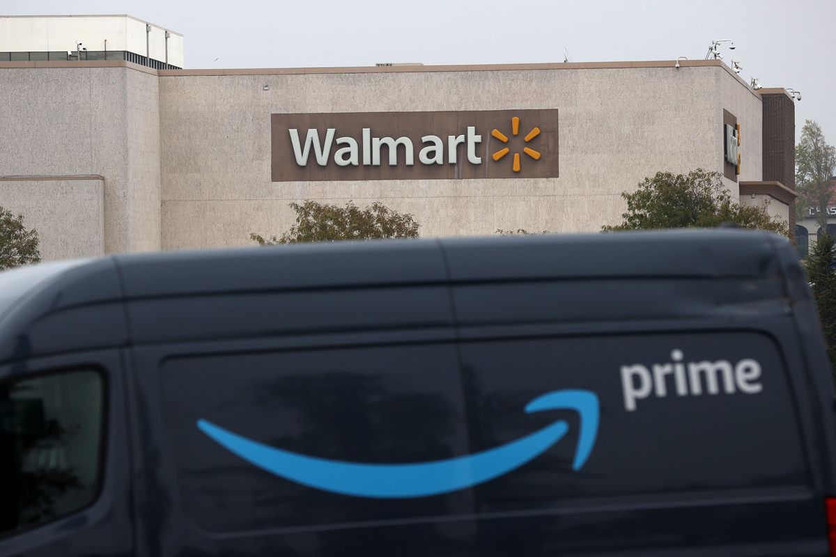 An Amazon Prime delivery van parked outside a Walmart store.