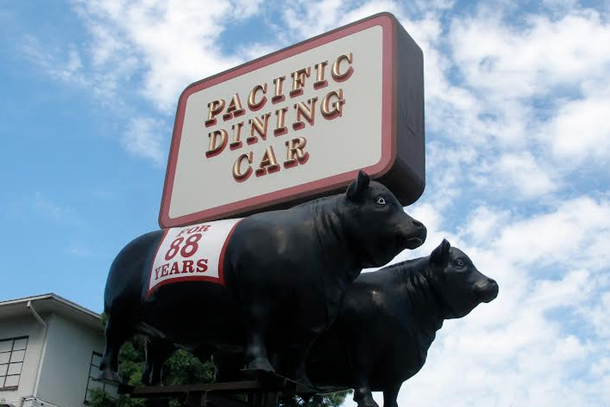 The historic Pacific Dining Car’s exterior, showing a statue of a cow.