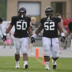 Highland's Jamahl Greer (8), Pita Tonga (50), Bryan Mone (52) and Adam Webber (11) lead the team onto the field prior to the start of the game against Herriman at Highland High School on Friday, Sept. 6, 2013. 