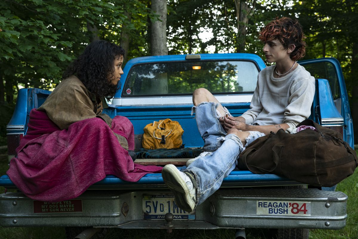 Taylor Russell (left) as Maren and Timothée Chalamet (right) as Lee in the back of a pickup truck in BONES AND ALL
