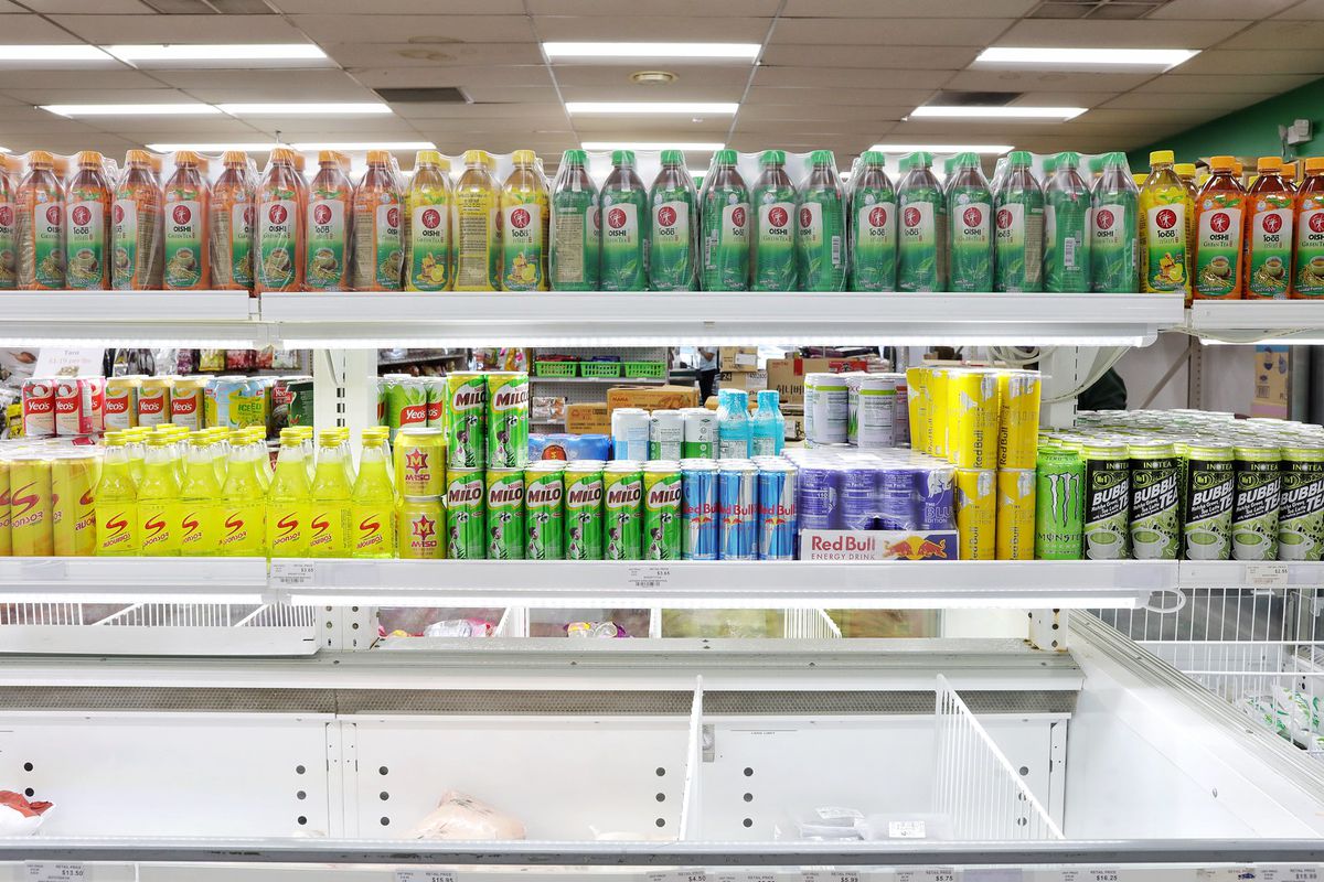 Shelves above a freezer compartment filled with rainbow-colored energy drinks and cold tea