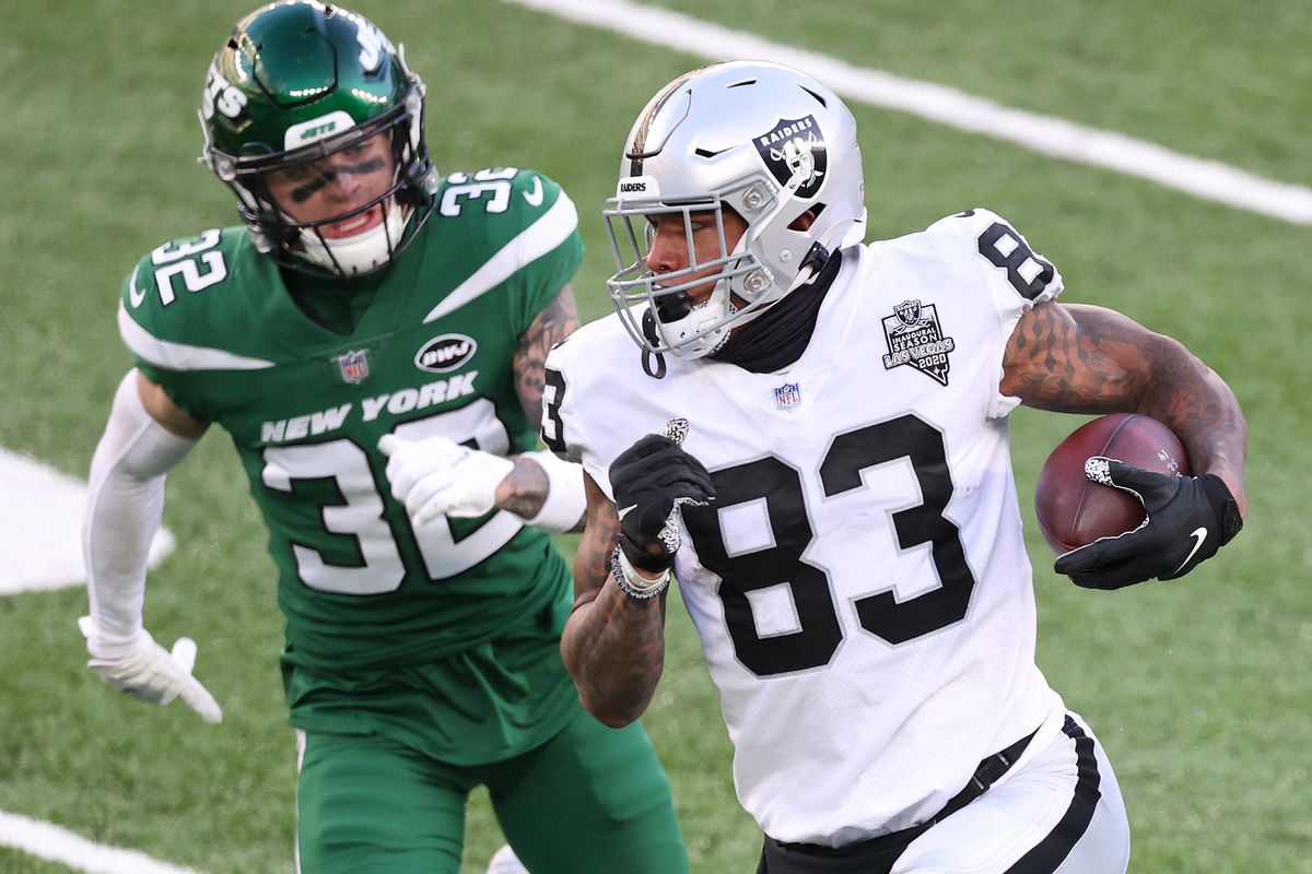 Darren Waller of the Las Vegas Raiders carries the ball as Ashtyn Davis of the New York Jets gives chase during the second half at MetLife Stadium on December 06, 2020 in East Rutherford, New Jersey.